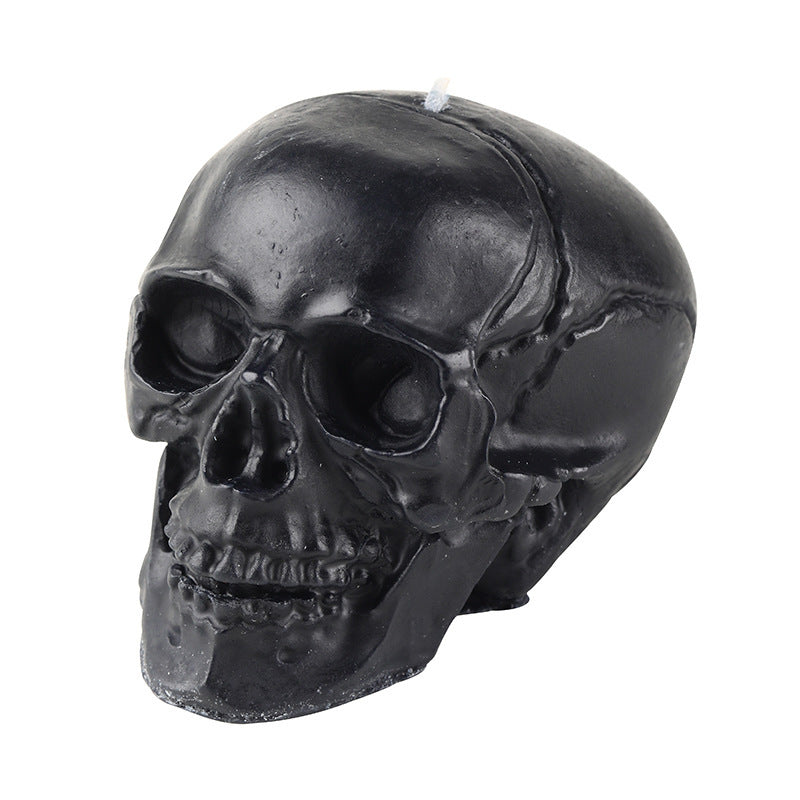 Black skull-shaped candle on a white background