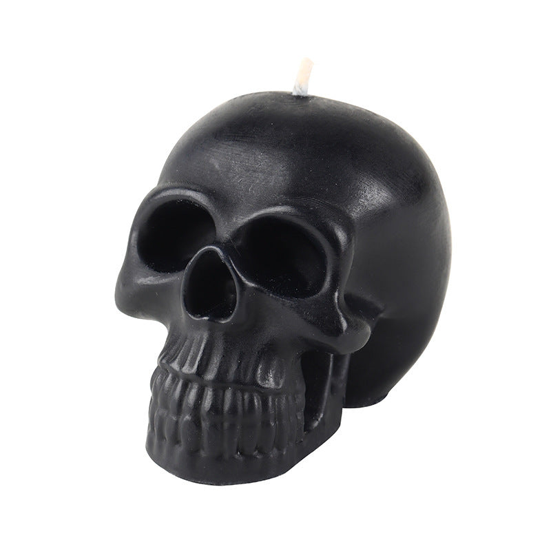Black skull-shaped candle on a white background